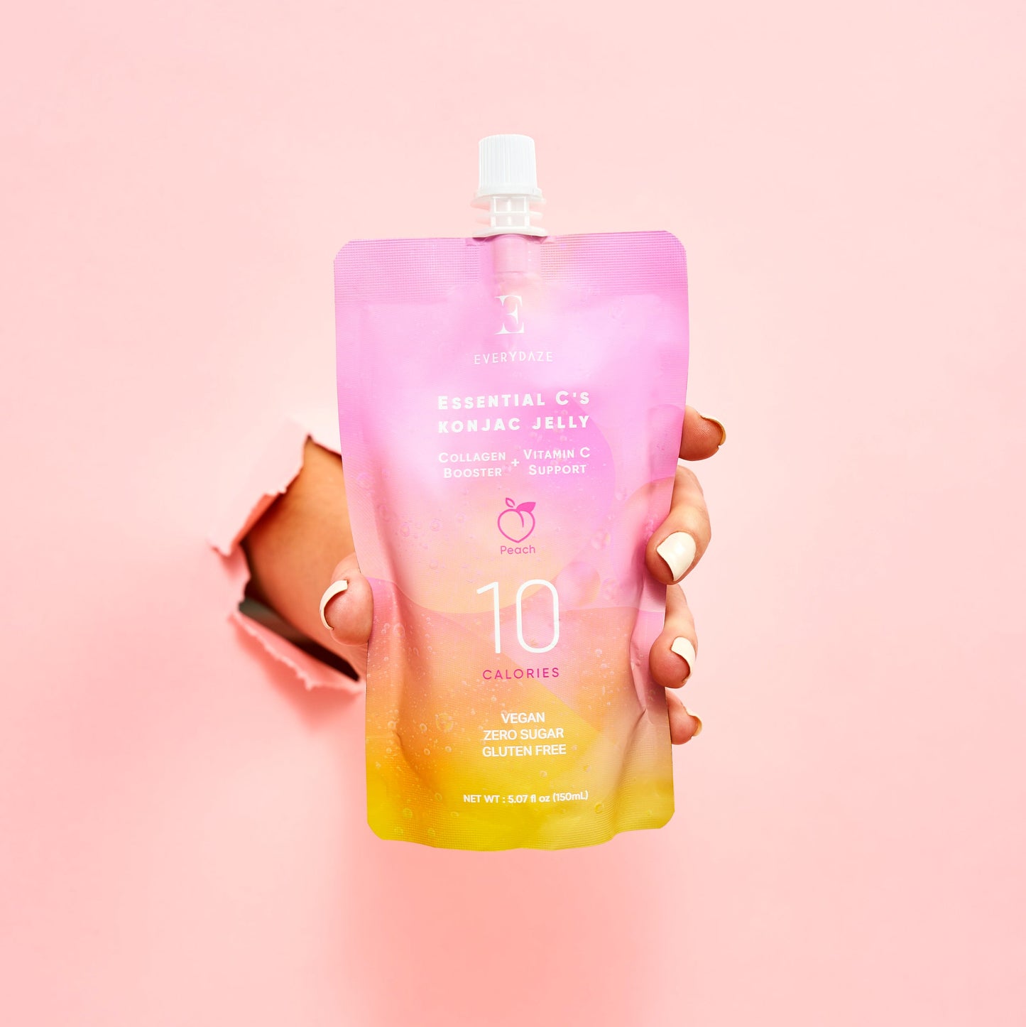 Osvežilni veganski konjak jelly z okusom breskve, obogaten s kolagenom in vitaminom C v roki na roza podlagi
